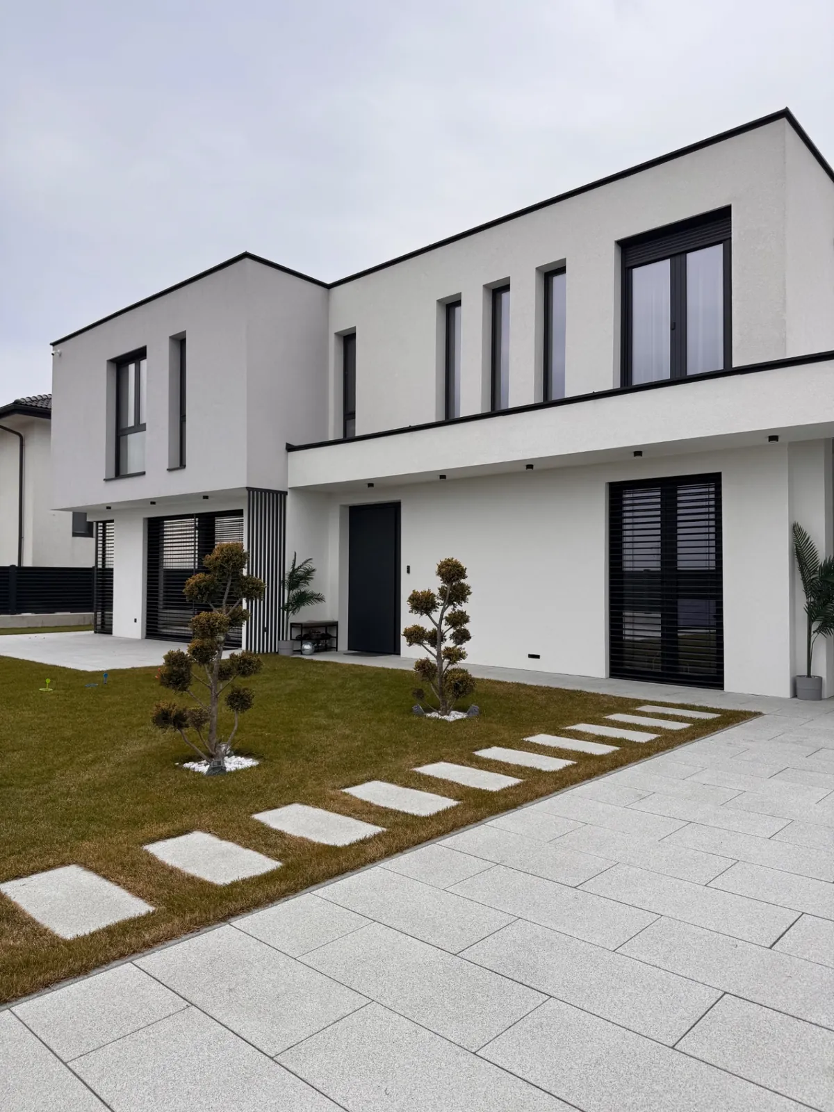 Fațadă modernă cu ușă pivotantă METGLASS — vedere exterioară din proiect real
